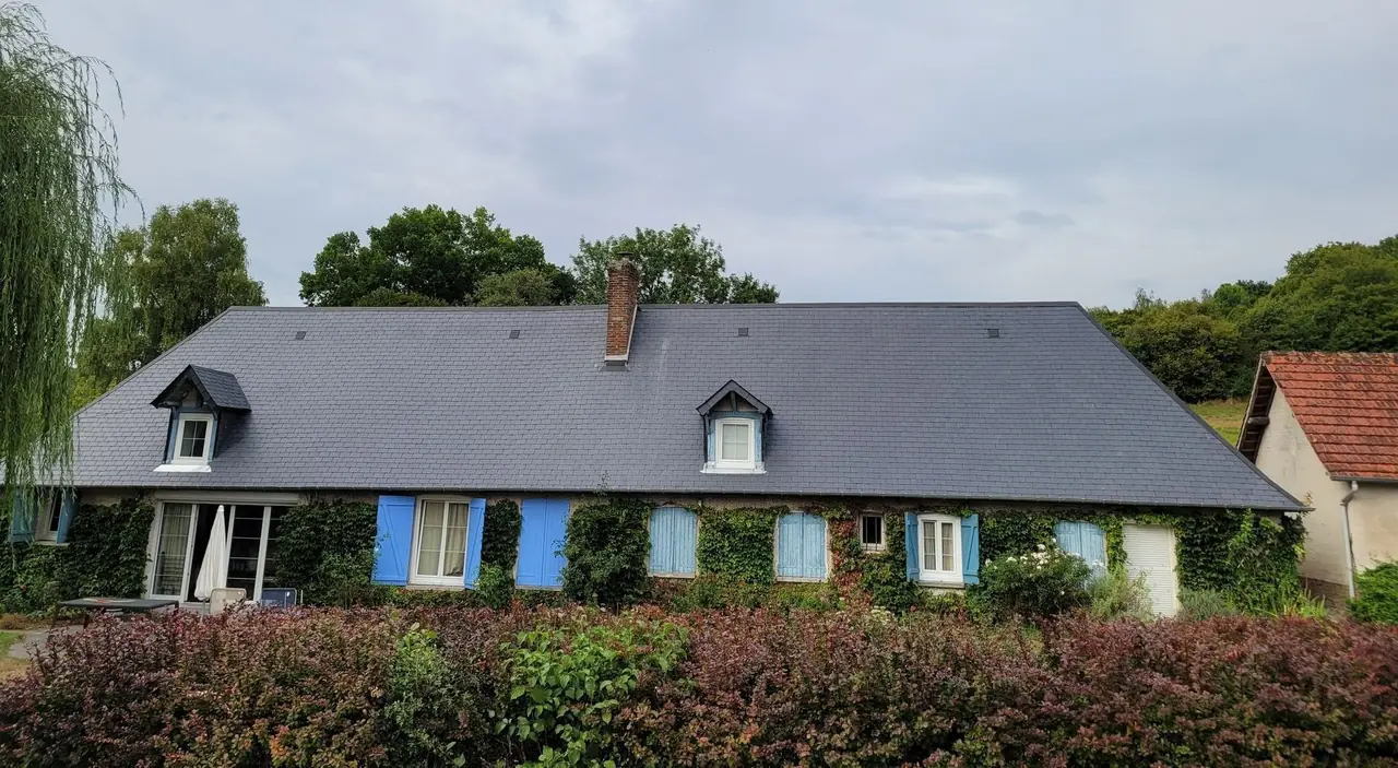Longère normande à volets bleus, couverte d’une toiture en ardoise refaite à neuf