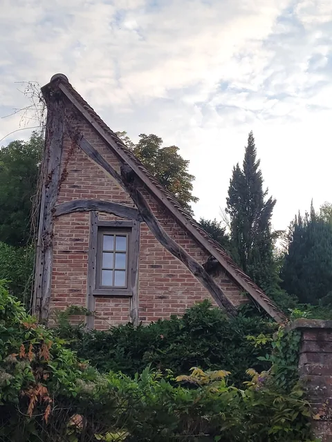 Pignon ancien en brique et colombage dont les tuiles sont à reprendre